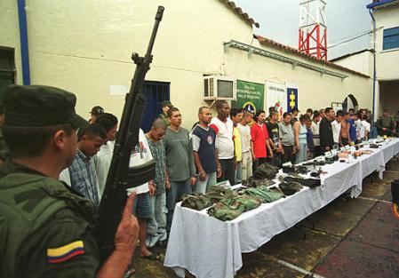 Полиция демонстрирует предположительно городских милиционеров, являющихся 
также членами левого повстанчества из Революционных Вооруженных Сил 
Колумбии, или FARC, которые были арестованы во вторник, 21 мая 2002 г. 
в Медельине. Фото и аннотация: Луис Бенавидес, агентство Ассошиэйтед Пресс. 
