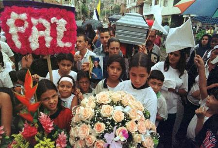 Дети идут с плакатом, на котором написано ''мир'', и гробом 10-летней девочки 
Иисет Адрианы Таскон в ходе ее похорон в в Медельине, в среду, 22 мая 2002, 
днем спустя после того, как она была убита в стычке между полицией и 
партизанами. Девять человек были убиты в ходе столкновений в Медельине между 
полицейскими и городской милицией Революционных Вооруженных Cил 
Колумбии, или FARC. 
Фото и аннотация: Луис Бенавидес, агентство Ассошиэйтед Пресс. 
