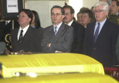 Вице-президент Франсиско Сантос, слева; колумбийский президент Альваро Урибе, в центре, и Генеральный прокурор Луис Камило Осорио, 
посещает похороны восьми солдат в Военной Школе, в Боготе, Колумбия, в среду, 7 мая 2003 г. Солдаты были убиты, когда армейские отряды 
штурмовали лагерь повстанцев, в котором те, согласно президентскому утверждению, содержали пленных. Фото и аннотация: Хайме Пуэбла, 
агентство Ассошиэйтед Пресс, среда 7 мая 2003 г., 17 ч. 50 мин. всемирного времени.