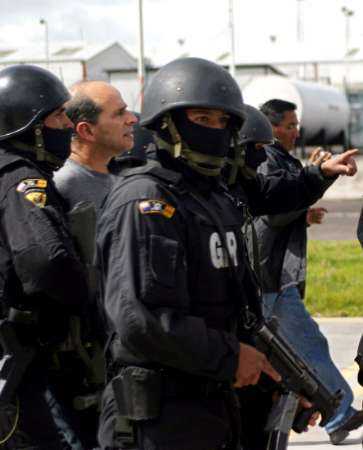 Команданте марксистской повстанческой армии Колумбии, FARC, Симон Тринидад (2-й слева) сопровождается эквадорскими полицейскими в Кито, 3 января 2004 г. Должностные лица заявили, что Тринидад, чье настоящее имя - Рикардо Пальмера, был арестован в больнице Кито и  является самым высокопоставленным членом партизанской армии, когда-либо захваченным. Фото и аннотация: Гильермо Гранха, агентство Рейтер, суббота 03 января 2004 г., 15 ч. 53 мин. всемирного времени