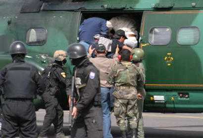 Команданте марксистской повстанческой армии Колумбии, FARC, Симон Тринидад загружен в военный вертолет эквадорскими полицейскими в Кито, 3 января 2004 г. Должностные лица заявили, что Тринидад, чье настоящее имя - Рикардо Пальмера, был арестован в больнице Кито и  является самым высокопоставленным членом партизанской армии, когда-либо захваченным. Фото и аннотация: Гильермо Гранха, агентство Рейтер, суббота 03 января 2004 г., 16 ч. 17 мин. всемирного времени.