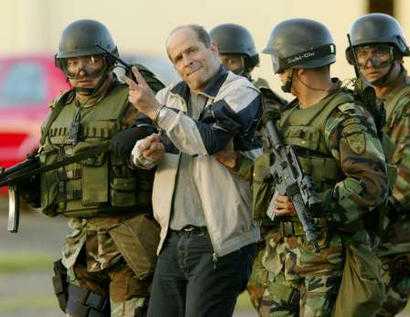Команданте колумбийских повстанцев Симон Тринидад сопровождается солдатами после его прибытия в армейский аэропорт Катам города Боготы, 3 января 2004 г. Команданте марксистской повстанческой армии Колумбии, FARC, был арестованный 2 января в больнице в соседнем Эквадоре.  Он является самым высокопоставленным членом партизанской армии, когда-либо захваченным. Фото и аннотация: Элиана Апонте, агентство Рейтер, суббота 03 января 2004 г., 18 ч. 54 мин. всемирного времени.