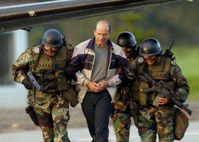Команданте колумбийских повстанцев Симон Тринидад сопровождается солдатами по прибытию в армейский аэропорт Катам города Боготы, 3 января 2004 г. Команданте марксистской повстанческой армии Колумбии, FARC, был арестован 2 января в больнице в соседнем Эквадоре.  Он является самым высокопоставленным членом партизанской армии, когда-либо захваченным. 