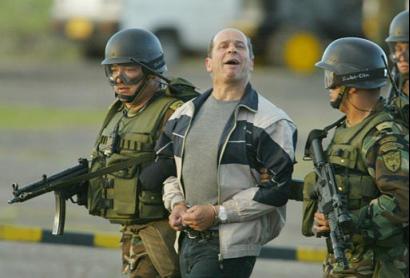 Симон Тринидад, один из семи членов руководящего Национального Секретариата Революционных Вооружённых Сил Колумбии, выкрикивает лозунги, будучи сопровождаемым срециальными силами на военной базе в Боготе, Колумбия, в субботу, 03 января 2004 г.  Эквадорские власти арестовали самого высокопоставленного члена партизанской армии, из когда-либо захваченных за четыре десятилетия партизанской войны, что является самой большой победой в кампании бескомпромиссного колумбийского Президента Альваро Урибе, направленной на сокпушение левого повстанчества. Фото и аннотация: Хавьер Галеано, агентство Ассошиэйтед Пресс, суббота 03 января 2004 г., 18 ч. 46 мин. всемирного времени