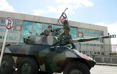 В воскресенье, 04 января 2004 г. солдаты стоят на посту на танкетке перед офисом министра юстиции и генерального прокурора в Боготе, Колумбия, где содержится повстанческий команданте Симон Тринидад. Тринидад, который был арестован в Кито эквадорской полицией в конце пятницы, является членом Революционных Вооружённых Сил Колумбии, или FARC, общим числом в 16,000 человек, самой большой группировки повстанцев в Колумбии. Он был одним из участников встреч на высшем уровне в ходе мирных переговоров с правительством, которые начались в январе 1999 г. Переговоры прекратились в феврале 2002 г., и армии возобновила боевые действия против FARC. Фото и аннотация: Хавьер Галеано, агентство Ассошиэйтед Пресс, воскременье 04 января 2004 г., 14 ч. 12 мин. всемирного времени.