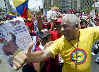 Сторонник венесуэльского Президента Уго Чавеса выражает ему свое приветствие в ходе марша в Каракасе 16 мая 2004 г. Сторонники Чавеса вышли на улицы в воскресенье, чтобы протестоват против того, что было охарактеризовано как ''иностранное вмешательство'' в Венесуэле. Чавес на прошлой неделе осудил заговор оппозиции по его убийству, поддержанный его врагами в Колумбии и Майами, обвинение, которое его противники отвергают. Фото и аннотация: Хорхе Сильва, агентство Рейтер, воскресенье 16 мая, 15 ч. 02 мин. всемирного времени