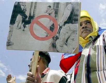 Сторонник венесуэльского Президента Уго Чавеса размахивает плакатом, осуждающим злоупотребления по отношению к иракским заключеным в ходе марша в Каракасе 16 мая 2004 г. Десятки тысяч сторонников Чавеса вышли на улицы в воскресенье, чтобы протестоват против того, что было охарактеризовано как ''иностранное вмешательство'' в Венесуэле. Чавес на прошлой неделе осудил заговор оппозиции по его убийству, поддержанный его врагами в Колумбии и Майами, обвинение, которое его противники отвергают. Фото и аннотация: Хорхе Сильва, агентство Рейтер, воскресенье 16 мая, 14 ч. 59 мин. всемирного времени.