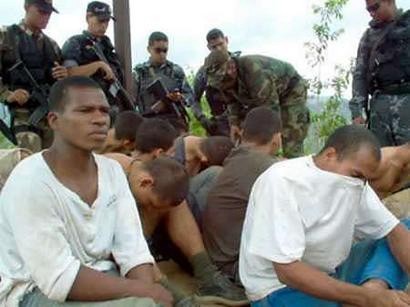 Предполагаемые бойцы колумбийских полувоенных формирований сидят, будучи захваченным в южных предместьях Каракаса 12 мая 2004 г. Президент Венесуэлы Уго Чавес заявил, что действия подразделения колумбийских полувоенных, захваченных около Каракаса на этой неделе, были частью запланированного ''вторжения'', поддержанного из США и Колумбии. Фото и аннотация: Карлос Родригес, агентство Рейтер, среда, 12 мая 2004 г., 18 ч. 06 мин. всемирного времени.