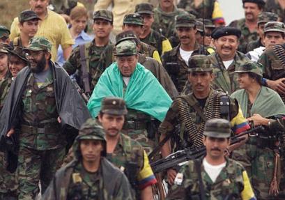 Мануэль Мараланда, с зеленым пончо, основатель и главным лидер Революционных Вооруженных Сил Колумбии, FARC, в ходе переговоров идет по Лос Пососу, что в южной Колумбии, на этой ахивной фотографии, относящейся к 8 февраля 2001 г. Маруланда вместе с примерно 40 товарищами создавал FARC 40 лет назад. Группа повстанцев разрослась примерно до 15 000 бойцов, которые устроили череду атак, совпавших по дате с годовщиной основания FARC в четверг. За истекшие пять дней по меньшей мере 13 человек были убиты и больше чем 100 ранены в ходе бомбежек, за которые возлагают ответственность на FARC. Фото и анотация: Рикардо Масалан, агентство Асошиэйтед Пресс, архив, понедельник 24 мая 2004 г, 14 ч. 30 мин. всемирного времени. (Слева в очках от Мануэля Маруланды - член Секретариата Главного штаба РВСК-АН, Председатель Болиарийского Союза за Новую Колумбию 
команданте Альфонсо Кано, справа в берете со звездой - член секретариата Главного штаба команданте Хорхе Брисеньо ''Моно Хохой'' - Рус. ред.)