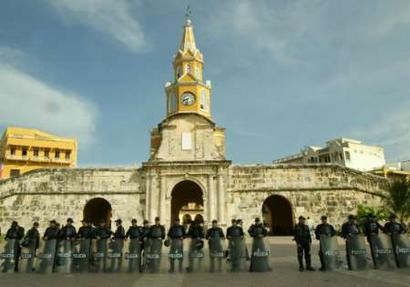 Колумбийский наряд антитеррористической полиции рядом с Центром Согласия в Картахене, 18 мая 2004 г. Соединенные Штаты начнут переговоры о свободной торговле с Колумбией, Перу и Эквадором позже, во вторник, с целью расширения зоны ее распространения в Латинской Америке по договоренности уже в следующем году. Общественные рабочие, организующие однодневную забастовку, чтобы осудить переговоры, как ожидается, выразят свой протест в ходе вечерней инаугурационной церемонии в усаженом пальмами колумбийском портовом городе Картахена. Фото и аннотация: Элиана Апонте, агентство Рейтер, вторник 18 мая, 11 ч. 04 мин. всемирного времени
