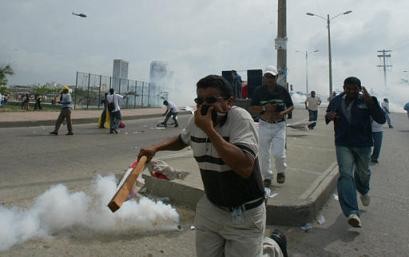 Протестующие бегут от слезоточивого газа, брошенного антитеррористической полицией в ходе марша, чтобы выступить против начала переговоров о свободной торговле между Колумбией и Соединенными Штатами во вторник, 18 мая 2004 г. Колумбия, Эквадор и Перу во вторник начали переговоры по созданию зоны свободной торговли с Соединенными Штатами в Картахене, что вызвало протесты, поскольку сельскохозяйственные и другие защищенные сектора экономики южноамериканских наций будут подвержены потерям рабочих мест. Фото и аннотация: Хавьер Галеано, агентство Ассошиэйтед Пресс, вторник 18 мая, 17 ч. 05 мин. всемирного времени