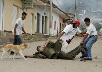 Колумбийский полицейский, который был смертельно ранен в ходе боя против Революционных Вооруженных Cил Колумбии (FARC), эвакуируется жителями Торибио, расположенного в 600 км к юго-западу от Боготы 14 апреля 2005 г. Трое полицейских и одна девочка были убиты, и, кроме того, 23 человека, включая восемь полицейских, были ранены в вооружёном столкновении. Фото и аннотация: Эдуардо Муньос, агентство Рейтер, четверг 14 апреля 2005 г., 21 ч. 55 мин. всемирного времени