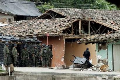 20 апреля 2005 г. колумбийские полицейские группируются рядом с остатками от дома, разрушенного в ходе боя в Торибио. В окрестностях Торибио колумбийская армия и Национальня полиция в течение семи дней вели бои против повстанцев Революционных Вооруженных Сил Колумбии (FARC), в ходе которых четверо человек были убиты, и, кроме того, 30 человек были ранены в столкновениях. Фото и аннотация: Эдуардо Муньос, агентство Рейтер, среда 20 апреля 2005 г., 04 ч. 11 мин. всемирного времени. REUTERS/Eduardo Munoz