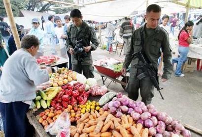 Колумбийские полицейские покупают продовольствие на рынке Торибио, что в департаменте Каука, 23 апреля 2005 г. Колумбийские солдаты в течение недели вели бои с Революционными Вооруженными Силами Колумбии, известной под испанской аббревиатурой FARC, в населенных пунктах по всей стране, в которых, по меньшей мере, четыре человека были убиты и ранены более 50. Фото и аннотация: Эдуардо Муньос, агентство Рейтер, суббота 23 апреля 2005 г., 01 ч. 01 мин. всемирного времени
