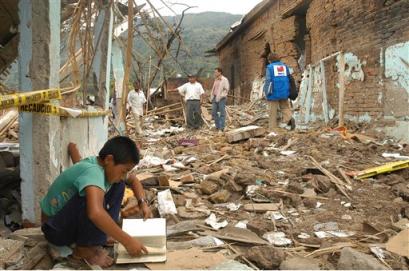 Эта фотография, опубликованная официальным агентством печати Колумбии, демонстрирует мальчика, разглядывающего книгу у входа в дом, разрушенного в ходе атаки повстанцев на Торибио, что в 240 милях к юго-западу от Боготы, в пятницу, 15 апреля 2005 г. В четверг повстанцы Революционных Вооруженных Сил Колумбии, или FARC, обстреляли деревню из самодельных ракетных установок и штурмовых винтовок, убив по меньшей мере трех полицейских и 9-летнего мальчика и оставив ранеными больше дюжины человек. Фото и аннотация: Фернандо Руис, Агентство Ассошиэйтед Пресс со ссылкой на Эс-Эн-И, пятница 15 апреля 18 ч. 51 мин. всемирного времени