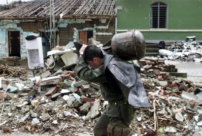 Полицейский несет ракету, кустарным путем изготовленную из газового баллона, оставленную при отступлении повстанцев из Торибио, Колумбия, что в 240 милях к юго-западу от Боготы, в среду, 20 апреля 2005 г. С четверга повстанцы Революционных Вооруженных Сил Колумбии, или FARC, напали на Торибио дважды. Фото и аннотация: Инальдо Перес, Агентство Ассошиэйтед Пресс, четверг 20 апреля, 14 ч. 48 мин. всемирного времени