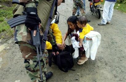 Солдат досматривает мешок женщины на придорожном блок-посту около индийского города Торибио, Колумбия, в субботу, 23 апреля 2005 г. Повстанцы Революционных Вооруженных Сил Колумбии заняли позиции здесь на склонах и обстреляли Торибио на прошлой неделе. Фото и аннотация: Зоя Сельская, Агентство Ассошиэйтед Пресс, суббота 23 апреля, 14 ч. 08 мин. всемирного времени