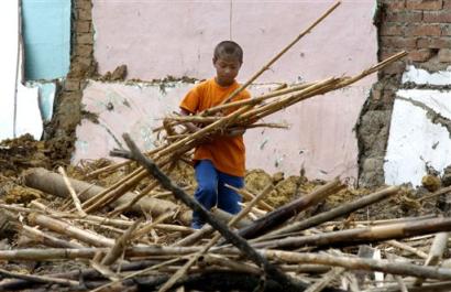 В городе Торибио, Колумбия, в субботу, 23 апреля 2005 г., Альберто, шести лет, помогает расчищать развалины обувного магазина его отца, который был разрушен ракетами повстанцев на прошлой неделе. Более 20 домов и коммерческих лавок были разрушены или повреждены после попытки мятежниками Революционных Вооруженных сил Колумбии, или FARC, взять под свой контроль этот маленький, индийский город. Фото и аннотация: Зоя Сельская, Агентство Ассошиэйтед Пресс, воскресенье 24 апреля, 16 ч. 24 мин. всемирного времени