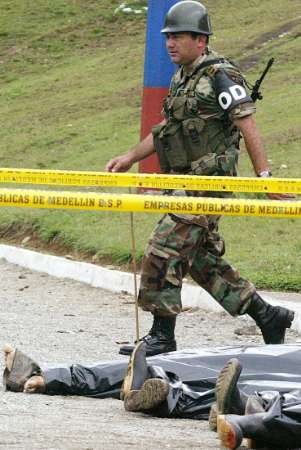 Колумбийский солдат идет мимо тел повстанцев FARC, убитых в бою, которые были продемонстрированы прессе в  муниципалитете Бельо, что в департаменте Антиокья 17 апреля 2005 г. По меньшей мере, 10 повстанцев Революционных Вооруженных Сил Колумбии (FARC) погибли в столкновениях с правительственными отрядами. Фото и аннотация: Альбейро Лопера, агентство Рейтер, воскресенье, 17 апреля 2005 г., 13 ч. 36 мин. всемирного времени