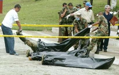 Прокурор  (слева) и колумбийский солдат несут тело повстанца FARC, убитого в бою, в в  муниципалитете Бельо, что в департаменте Антиокья 17 апреля 2005 г. По меньшей мере, 10 повстанцев Революционных Вооруженных Сил Колумбии (FARC) погибли в столкновениях с правительственными отрядами. Фото и аннотация: Альбейро Лопера, агентство Рейтер, воскресенье, 17 апреля 2005 г., 13 ч. 39 мин. всемирного времени.