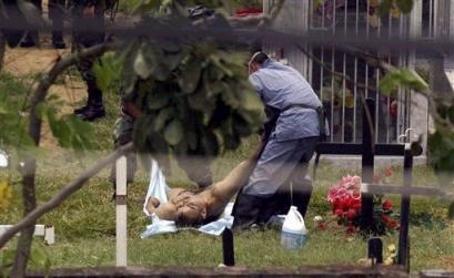 Рабочие морга на кладбище занимаются солдатом, убитым левыми повстанцами в кладбище в Таме, что в северо-восточном государстве департаменте Араука, в четверг, 7 апреля 2005 г. Семнадцать солдат были убиты в среду вечером, когда военный конвой попал в засаду, устроенную повстанцами Революционных Вооруженных Сил Колумбии, FARC. Фото и аннотация: агентство Ассошиэйтед Пресс, четверг, 07 апреля 2005 г., 16 ч. 35 мин. всемирного времени