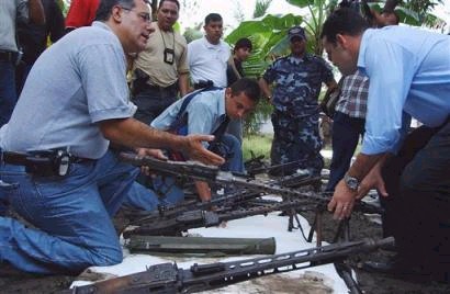 Министр Безопасности Гондураса Оскар Альварес, слева, держит оружие, найденное в ходе полицейской операции в Чолома, что на Севере Гондураса, в пятницу, 15 апреля 2005 г. Почти 200 единиц оружия было найдено, причем согласно Альваресу, оно было предназначены для продажи Революционным Вооруженным Силам Колумбии, или FARC. Фото и аннотация: Хосе Кантарерро, агентство Ассошиэйтед Пресс, пятница, 15 апреля 2005 г., 10 ч. 53 мин. всемирного времени
