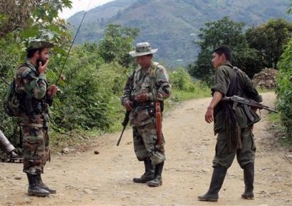 Партизаны Революционных Вооруженных Сил Колумбии, или FARC, включая команданте Карлоса Патиньо, слева, патрулируют дорогу около города Такуэйо, Колумбия, что в 240 милях к юго-западу от Боготы, в пятницу 22 апреля 2005 г. Сражения между повстанцами и правительственными войсками в муниципалитете продолжались почти в течение недели. Фото и аннотация: Инальдо Перес, агентство Ассошиэйтед Пресс, пятница, 15 апреля 2005 г., 13 ч. 50 мин. всемирного времени