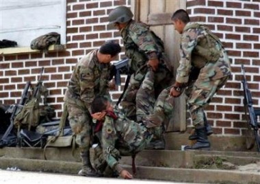 Солдаты помогают смертельно раненному товарищу, подстреленному снайпером повстанцев в ходе сражения в Такуэйо, в четверг 28 апреля 2005 г. Правительственные отряды восстановили контроль над этим ключевым городом на юго-западе Колумбии, отбив его у повстанцев Революционных Вооруженных Сил Колумбии, или FARC. Фото и аннотация: Фабио Самора, агентство Ассошиэйтед Пресс со ссылкой на Эль Тьемпо, пятница, 29 апреля 2005 г., 15 ч. 22 мин. всемирного времени