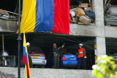 Пожарные вывешивают большой колумбийский флаг в Ногаль-Клубе в Боготе, 9 февраля 2003. Колумбия и Соединенные Штаты возложили на марксистских повстанцев ответственность за субботний взрыв автомобильной бомбы, которая превратила в руины клуб высшего общества, убив по меньшей мере 32 человек и ранив приблизительно 160 в этом тяжелейшем для Боготы за прошедшие десятилетия терракте. Аннотация и фото: Мигель Гомес, агентство Рейтер; суббота, 08 февраля 2003 г., 09 ч. 22 мин. всемирного времени