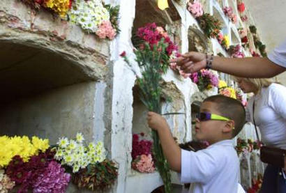 Ребенок возлагает цветы на Центральном кладбище Боготы в ходе акций протеста против насилия и взрыва автомобильной бомбы в Ногаль-Клубе, 09 февраля 2003. Колумбия и Соединенные Штаты возложили на марксистских повстанцев ответственность за субботний взрыв автомобильной бомбы, которая превратила в руины клуб высшего общества, убив по меньшей мере 32 человек и ранив приблизительно 160 в этом тяжелейшем для Боготы за прошедшие десятилетия терракте. Аннотация и фото: Элиана Апонте, агентство Рейтер; воскресенье, 09 февраля 2003 г., 01 ч. 07 мин. всемирного времени