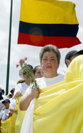 Колумбийцы водружают флаг в ходе акций протеста против насилия и взрыва автомобильной бомбы в Ногаль-Клубе, 09 февраля 2003. Колумбия и Соединенные Штаты возложили на марксистских повстанцев ответственность за субботний взрыв автомобильной бомбы, которая превратила в руины клуб высшего общества, убив по меньшей мере 32 человек и ранив приблизительно 160 в этом тяжелейшем для Боготы за прошедшие десятилетия терракте. Аннотация и фото: Элиана Апонте, агентство Рейтер; воскресенье, 09 февраля 2003 г., 01 ч. 52 мин. всемирного времени