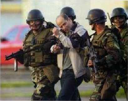 Команданте колумбийских повстанцев Симон Тринидад сопровождается солдатами после его прибытия в армейский аэропорт Катам города Боготы, 3 января 2004 г. Команданте марксистской повстанческой армии Колумбии, FARC, был арестованный 2 января в больнице в соседнем Эквадоре.  Он является самым высокопоставленным членом партизанской армии, когда-либо захваченным. Фото и аннотация: Элиана Апонте, агентство Рейтер, суббота 03 января 2004 г., 18 ч. 54 мин. всемирного времени.