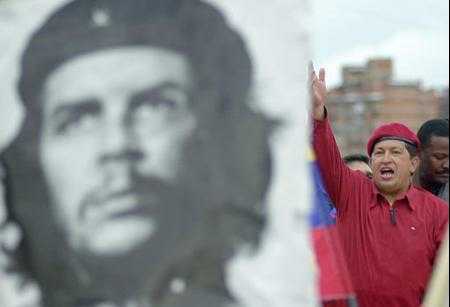 Venezuelan President Hugo Chavez greets his supporters next to a poster of the Cuban 
revolution hero Ernesto 
