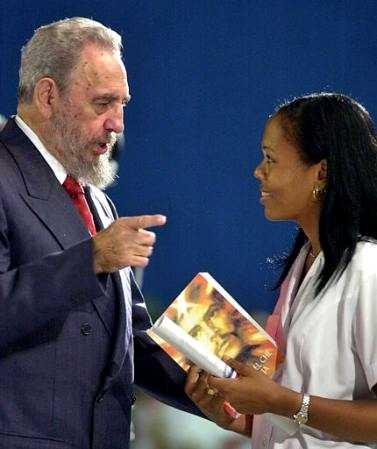 Cuban President Fidel Castro talks to a graduate student of the School of Medicine of Havana, 
during a graduation ceremony at the Karl Marx theater in Havana, Cuba Tuesday Aug. 
13, 2002. Castro gave the student a copy of ''The Diary of Che Guevara in Bolivia.'' 
(AP Photo/Cristobal Herrera)