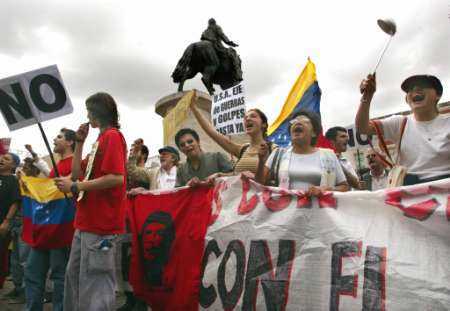 Че в Испании. Сторонники президента Уго Чавеса в Мадриде, на 
Пуэрто-дель-Соль, с транспарантами в руках скандируют лозунги, а также демонстрируют 
эмблемы и флаги в поддержку Венесуэльского президента Уго Чавеса, 
который прилетел в четверг в Мадрид для того, чтобы посетить встречу на 
высшем уровне стран Европейского Союза с главами Латиноамериканских государств 
в Мадриде, 17 мая 2002. Это - первая поездка Чавеса за пределы Венесуэлы, начиная 
с неудавшегося переворота в прошлом месяце. Эмблема гласит: 