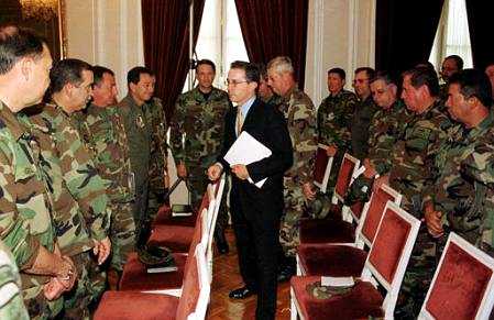 Colombian President Alvaro Uribe (C) talks during a meeting with high ranking military officials 
at the Narino Palace in Bogota, August 14, 2002. The United States on Wednesday applauded 
Uribe's new emergency tax to fund a military buildup against leftist rebels and said the measure 
should encourage Washington to keep up its aid to the war-torn nation. 
REUTERS/Fernando Ruiz-Presidencia