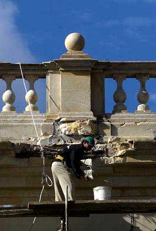 
A worker repairs the damage to the presidential palace caused by a mortar launched during 
the inauguration ceremony for President Alvaro Uribe, in Bogota, Colombia Friday Aug. 
9, 2002. At least one shell hit the palace on Wednesday during the attack blamed on rebels of the Revolutionary Armed Forces 
of Colombia, FARC. (AP Photo/John Moore)