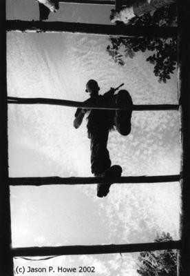 A rebel traverses an overhead ladder as part of an obstacle course. Photo: Jason P.Howe, 2002.