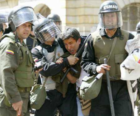 olombian anti-riot policemen arrest a student during a demonstration in a central street of 
Bogota, September 16, 2002. State workers in Colombia staged a one-day strike on Monday 
in the first major challenge to new cost cuts set by President Alvaro Uribe to help pay for a 
military build-up. The government imposed tight security in case leftist rebels infiltrated the 
protest by the 800,000 workers, who oppose Uribe's plans to cut some wage benefits, raise 
the retirement age and make it cheaper to fire staff. REUTERS/Jose Miguel Gomez