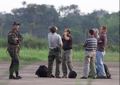 Колумбийский полицейский, слева, 
принимает группу неустановленных американских должностных лиц, которые 
только что прибыли из посольства в Боготе на взлетную полосу аэропорта 
Флоренсия, в 235 милях к югу от Боготы, Колумбия, в четверг, 13 февраля 2003. 
Американский правительственный самолет, перевозивший четырех американцев 
и колумбийца потерпел в четверг аварию в южной Колумбии, как установлено при 
двух погибших из числа находившихся на борту, и должностные лица 
беспокоились, что оставшиеся в живых были захвачены левыми повстанцами. 
Фото и аннотация: Хавьер Галеано, агентство Ассошиэйтед Пресс, четверг 
13 февраля, 08 ч. 58 мин. всемирного времени
