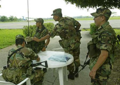 Des soldats colombiens montent la garde dans 
laéroport Florencia pour la sauvegarde de la sécurité, le 
14 février 2003. Comme des fonctionnaires colombiens ont déclarés, 
lavion marqué comme un monomoteur ``Cessna 208