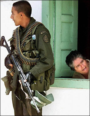 Выглядывающая женщина наклоняется из окошка в Гранаде, в 70 км к востоку от Медельина, Колумбия, поскольку 
антипартизанский полицейский патрулирует улицы, после того, как Президентский вертолет делегации Альваро Урибе 
был обстрелян Революционными Вооруженными Силами Колумбии (FARC-EP). Фото и аннотация: Фредди Амарилес, 
агентство Франс Пресс, воскресенье, 17 августа, 20 ч. 21 мин. всемирного времени