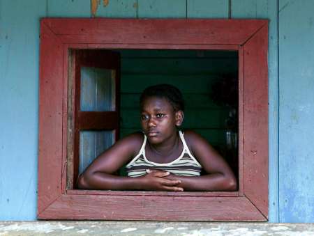 Пятнадцатилетняя колумбийская беженка Натача Мурильо выглядывает окна 
своего жилища в отдаленной деревушке Хаке в в Дарьенских джунглях Панамы 
21 марта 2002 г. Фото и аннотация: Альберто 
Лоуэ, агентство  Рейтер для проекта: Особенности истории. Панама. Колумбийские 
беженцы, 21 марта 2002 г.