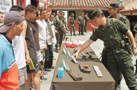 Полицейские осматривают оружие, захваченное у 19 арестованных повстанцев, 
принадлежащих, предположительно, отряду городской милиции с членами 
Революционных Вооруженных Сил Колумбии, FARC, и Армии Национального 
Освобождения, ELN, в Медельине, приблизительно в 155 милях к северо-западу от 
Боготы, в четверг, 7 марта 2002 г. Полиция утверждает, что повстанцы планировали 
срыв воскресных парламентских выборов. Фото и аннотация: Луис Бенавидес, 
агентство Ассошийэтед Пресс, четверг, 07 марта 2002 г.