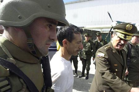 Шеф национальной полиции Луис Эрнесто Хилиберт, справа, и полицейский 
сопровождают Луиса Альфредо Праду, в центре, предположительно, лидера 
повстанцев Революционных Вооруженных сил Колумбии, FARC, в Боготе, 
Колумбия, в понедельник, 8 июля 2002 г. Прада как установлено, был подпольным 
руководителем захвата в плен двенадцати законодателей из здания провинциального 
парламента в ходе хорошо организованной акции в Кали в апреле текущего, 2002 
года. Фото и аннотация: Хавьер Галеано, агентство Ассошиэйтед Пресс, понедельник, 
08 июля 2002 г., 18 ч. 10 мин. всемирного времени