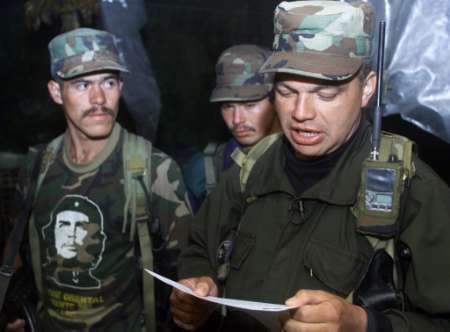 Команданте Революционных Вооруженных Сил Колумбии (FARC), известный 
как Байрон,  25 июня 2002 г., из секретного места в Колумбийских горах,
зачитывает документ, объявляющий наступление против Колумбийского 
правительства.Фото и аннотация: Элиана Апонте, агентство Рейтер, 25 июня 2002 г. 
