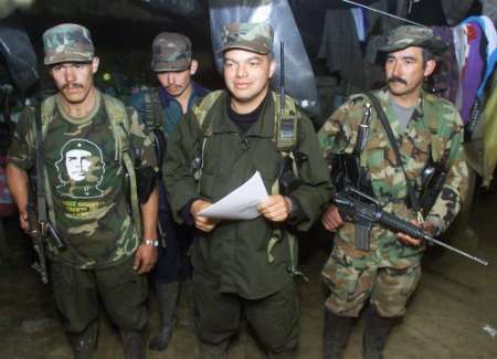 Команданте Революционных Вооруженных Сил Колумбии (FARC), известный 
как Байрон, зачитывает документ, объявляющий наступление против Колумбийского 
правительства из секретного   места в Колумбийских горах, 25 июня 2002 г.
Фото и аннотация: Элиана Апонте, агентство Рейтер, 25 июня 2002 г.<br><br> 
От Руской Редакции. Справа, с автоматом в руках стоит команданте РВСК-АН
Адан Искьердо, недавно павший смертью храбрых за торжество идеалов Революции в бою с 
рейнджерами.
