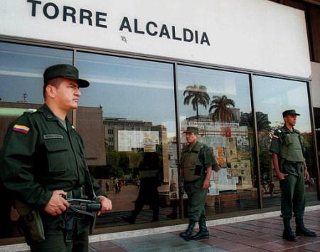Полицейские стоят на страже перед зданием муниципалитета Медельина, в 
155 милях к северо-востоку от Боготы, Колумбия, в среду, 26 июня 2002 г. 
Революционные Вооруженные Силы Колумбии, или FARC, угрожали казнью мэру 
Медельина Джону Марио Родригесу, наряду с множествами других мэров по всей 
стране, если те не уйдут в отставку. Национальное правительство предоставило 
находящимся в опасности мэрам телохранителей и другие меры безопасности, 
а также предложило тем из мэров, кто находятся в наибольшей опасности, 
работать на внутренних военных базах. Фото и аннотация: Освальдо Паэс, 
агентство Ассошиэйтед Пресс, среда, 26 июня 2002 г.