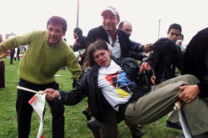Протестующие оказывают помощь студенту, который был ранен, 
когда полиция применила резиновые пули и слезоточивый газ по толпе 
приблизительно из 1 500 демонстрантов, которые прошли маршем к американскому 
посольству, чтобы протестовать против войне в Ираке, в четверг, 27 марта 2003, 
в Боготе, Колумбия. Приблизительно 1 500 протестующих, главным образом 
студенты университета, пришли к зданию посольства, где полиция применила 
слезоточивый газ и резиновые пули после того, как демонстраторы зажгли шины, 
бросили небольшие взрывпакеты в полицию и подожгли американский флаг. 
Ни о каких серьезных повреждениях не сообщается. Фото и аннотация: Фернандо 
Вергара, агентство Ассошиэйтед Пресс, четверг 27 марта 2003 г; 21 ч. 00 мин. 
всемирного времени