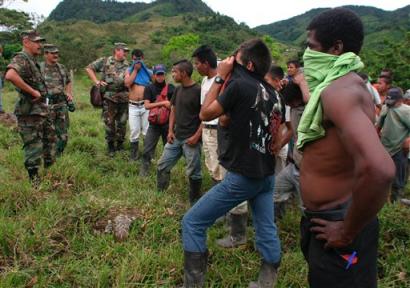 Командующий колумбийской армией генерал Мартин Карреньо, слева, беседует с бойцами полувоенных формирований из Сил Крестьянской Самообороны Касанаре, или ACC, которые сдались армии и ждут эвакуации на военную базу в сельском районе Таурамена в 90 милях к востоку от Боготы, в понедельник, 27 сентября 2004 г. Согласно заявлению самого Карреньо, 27 бойцов ACC были уничтожены и еще почти 100 были захвачены или добровольно сдались в ходе четырехдневного военного наступления против диссидентской крайне правой группировки, которая отказалась участвовать в мирном процессе. Фото и аннотация: Фернандо Вергара, агентство Ассошиэйтед Пресс, понедельник 27 сентбря 2004 г., 18 ч. 43 мин. всемирного времени
